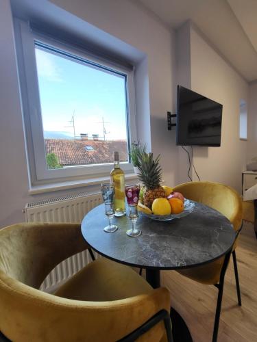 a table with a bowl of fruit and wine glasses at Villa Vino & Grad in Zagreb