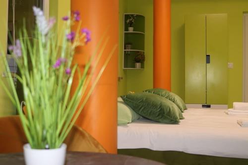 Villa Vino & Grad في زغرب: غرفة نوم بسرير وجدران خضراء برتقالية