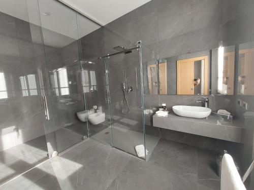 uma casa de banho com uma cabina de duche em vidro e um lavatório. em Foresteria La Vista em Cremona