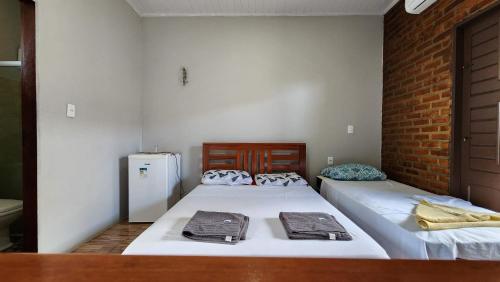 - 2 lits dans une chambre avec un mur en briques dans l'établissement Suítes Green Village Flecheiras, à Flecheiras