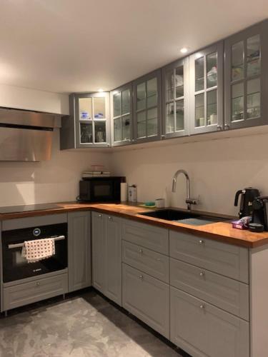 a kitchen with white cabinets and a sink at Cozy place close to beautiful nature in Ballerup