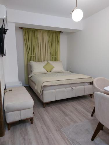 1 dormitorio con 1 cama grande y cortinas verdes en JAGODINA apartman en Jagodina