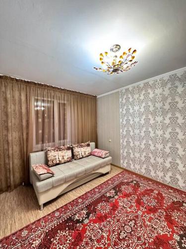 a living room with a couch and a red rug at Аренда с Самостоятельным Заездом in Pavlodar