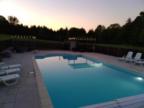 une grande piscine avec des chaises dans l'établissement The Sidings, Les Gites de L'Ancienne Gare, à Piégut-Pluviers