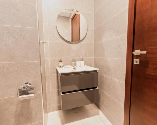 a bathroom with a sink and a mirror at The Valley Villa in Accra