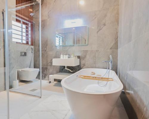 y baño con bañera, lavabo y aseo. en The Valley Villa, en Accra