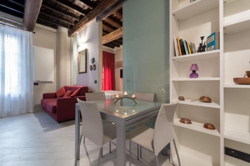 ein Esszimmer mit einem Glastisch und weißen Stühlen in der Unterkunft Perla al centro di Torino - next Mole in Turin