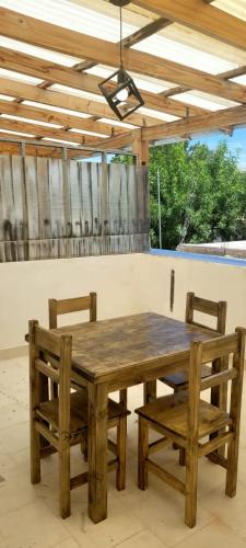 a wooden table with two chairs and a wooden ceiling at Alto Valle Cinco Saltos in Cinco Saltos
