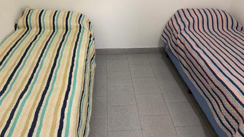 two beds sitting next to each other in a room at Alto Valle Cinco Saltos in Cinco Saltos