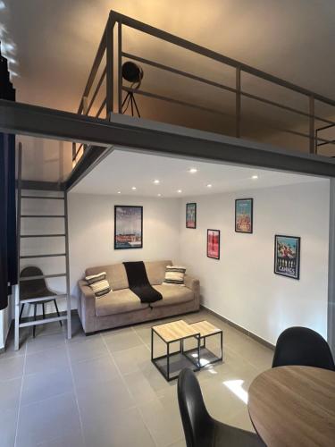 un salon avec un lit mezzanine et un canapé dans l'établissement LOFT CANNES Chaleureux - Climatisation - wifi - 650 m du Palais des festivals, plage, à Cannes