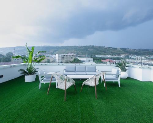 a balcony with a table and chairs on the grass at The Valley Villa in Accra