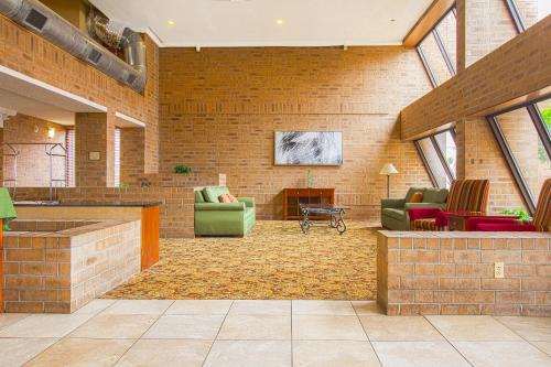 a large living room with chairs and a fireplace at Tulsa Square Hotel Central, I-44 By OYO in Tulsa