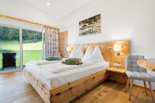 Un dormitorio con una cama y un escritorio y una ventana. en Appartement Ferienhof Ortnergut, en Eben im Pongau