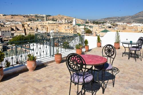 d'une terrasse avec une table et des chaises sur un balcon. dans l'établissement Riad Fes EL KAID, à Fès