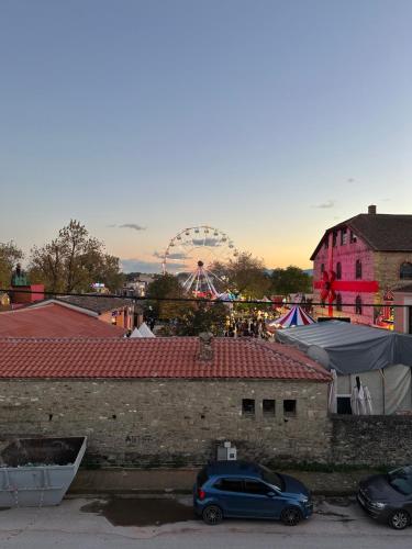 a car parked in a parking lot with a ferris wheel at Plex House in Tríkala