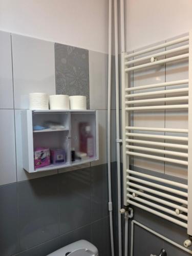 a bathroom with a toilet and a shelf with towels at Adrian Home Libra in Ploieşti