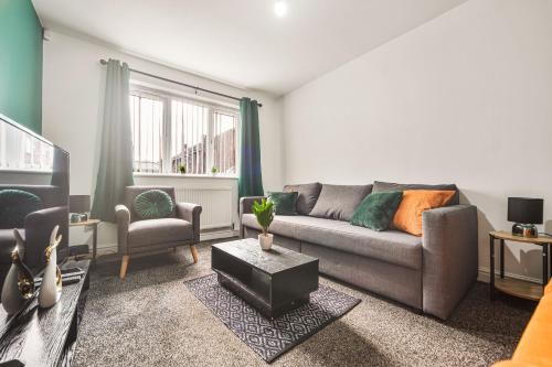 ein Wohnzimmer mit einem Sofa und einem TV in der Unterkunft Exclusive house for contractors and families in Buttershaw