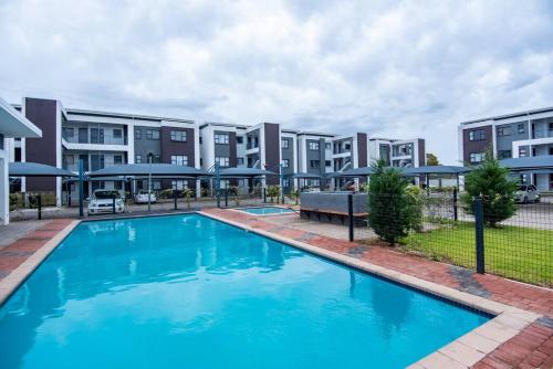 a large blue pool in front of a building at Luxe Lumiere @ The Habitat Alpha in Gaborone