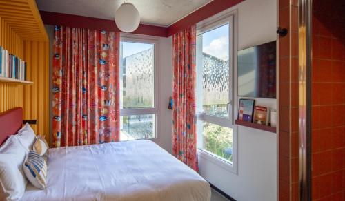 a bedroom with a bed and two windows at JOST Hôtel Le Havre Centre Gare in Le Havre