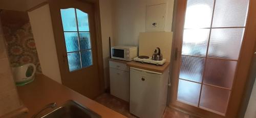 a small kitchen with a microwave and a refrigerator at Apartma Františkovy Lázně in Františkovy Lázně