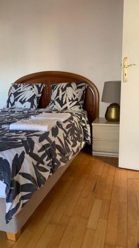Bett in einem Schlafzimmer mit Holzboden in der Unterkunft PAVILLON & Jardinet A 5 MN PARIS , 30 MN STADE de FRANCE au pied du RER B in Cachan