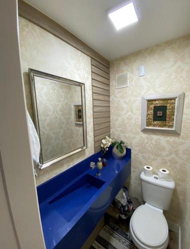 uma casa de banho com um lavatório azul e um WC. em Apto alto padrão em Florianópolis em Florianópolis
