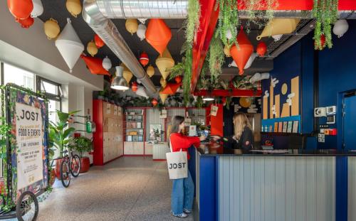 a person standing at a counter in a restaurant at JOST Hôtel Le Havre Centre Gare in Le Havre