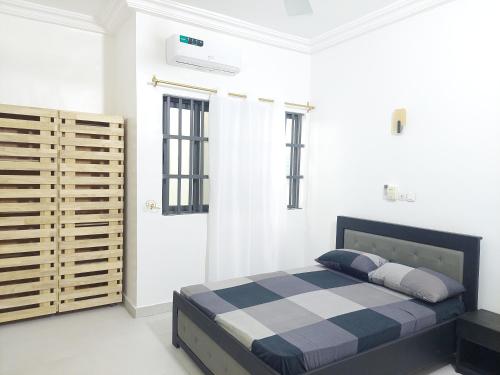 a bedroom with a bed in a white room at Barro luxury in Cotonou