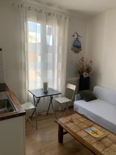un salon avec une table et un canapé dans l'établissement 3 Hebergements à 5 minutes de Paris et 30 MN Stade de France, à Cachan