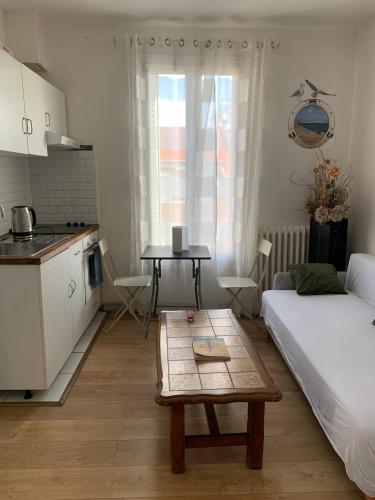 Cette petite chambre comprend un lit et une table. dans l'établissement 3 Hebergements à 5 minutes de Paris et 30 MN Stade de France, à Cachan