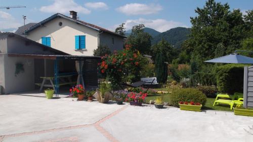 una casa con un jardín con flores y un patio en GM en Bagnères-de-Bigorre