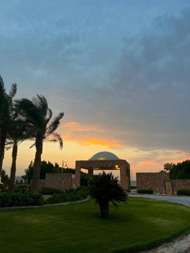 a building with a palm tree and a building with a dome at Makady heights in Hurghada