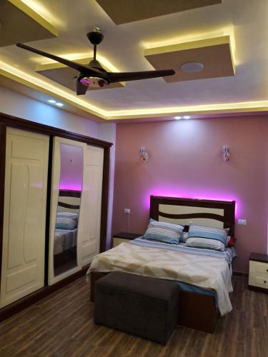 a bedroom with a bed with purple lighting at Cosy appartment in city in Luxor