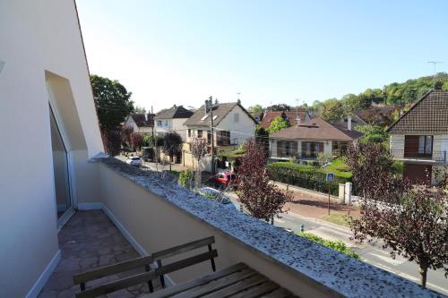 a balcony with a bench and a view of a street at Le Parc du Moulin in Montfermeil