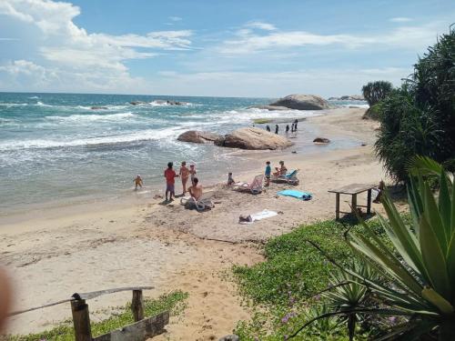 a group of people on a beach near the ocean at Beach Bungalow Yala in Kirinda
