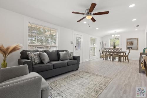 a living room with a couch and a ceiling fan at The Good Vibes Only Cottage in Tampa