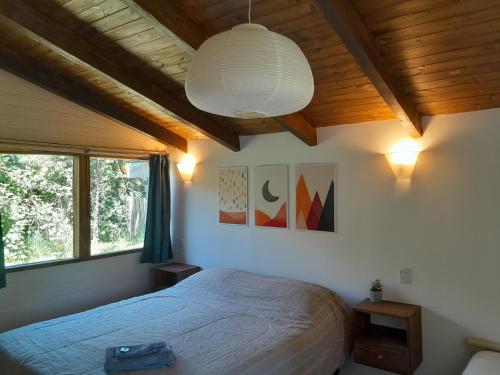 a bedroom with a large bed and a ceiling at Cabañas Tierra Verde in El Bolsón