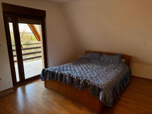 sypialnia z łóżkiem i przesuwnymi szklanymi drzwiami w obiekcie VIKENDICA TOJA - Brcko w mieście Brczko