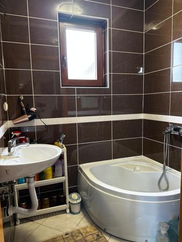 La salle de bains est pourvue d'un lavabo, d'une baignoire et d'une fenêtre. dans l'établissement VIKENDICA TOJA - Brcko, à Brčko