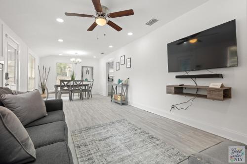 a living room with a couch and a flat screen tv at The Good Vibes Only Cottage in Tampa