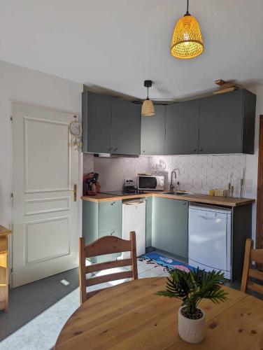 une cuisine avec une table en bois et une salle à manger dans l'établissement Appartement 4 couchages ,plein sud calme, à Les Deux Alpes