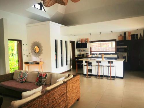 sala de estar con sofá y cocina en Casa del Dodo Villa de luxe avec piscine, en Rivière Noire