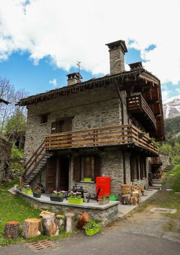 a large stone house with a porch on the side of it at Maison Chez Les Roset in Arvier