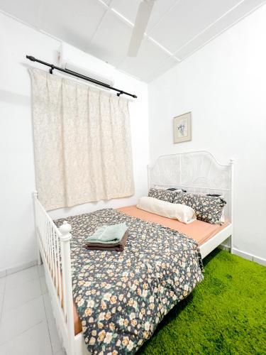 a white bedroom with a bed and a window at Homestay Dsunway in Petaling Jaya
