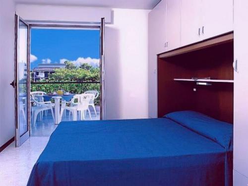 una camera da letto con un letto e un balcone con un tavolo di Residence Regent Beach a Bibione