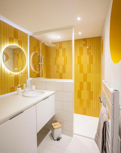 une salle de bain avec un lavabo, une douche et un miroir dans l'établissement Chats Perchés, à Bouzigues