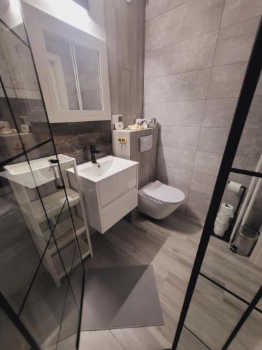 a bathroom with a sink and a toilet at Apartament Nad Klifem SEA VIEW in Gdynia