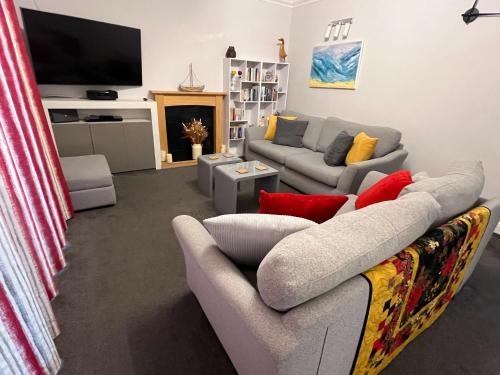 a living room with two couches and a tv at Rockmount Court in Bournemouth