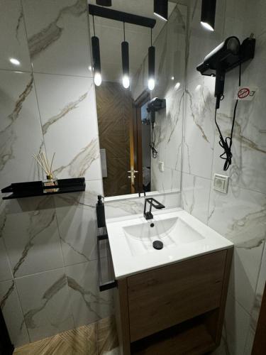 a bathroom with a white sink and a mirror at Avelov Art Studio in Pamporovo