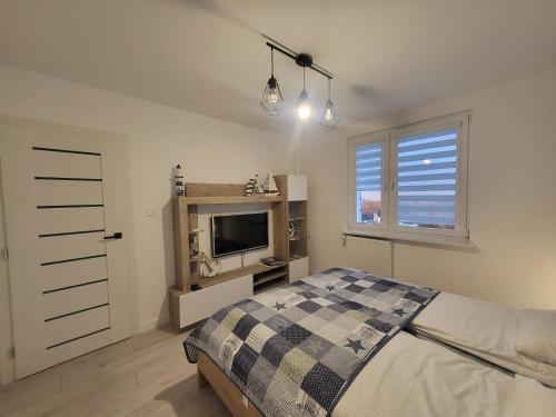 - une chambre avec un lit, une télévision et une fenêtre dans l'établissement Apartament Nad Klifem SEA VIEW, à Gdynia